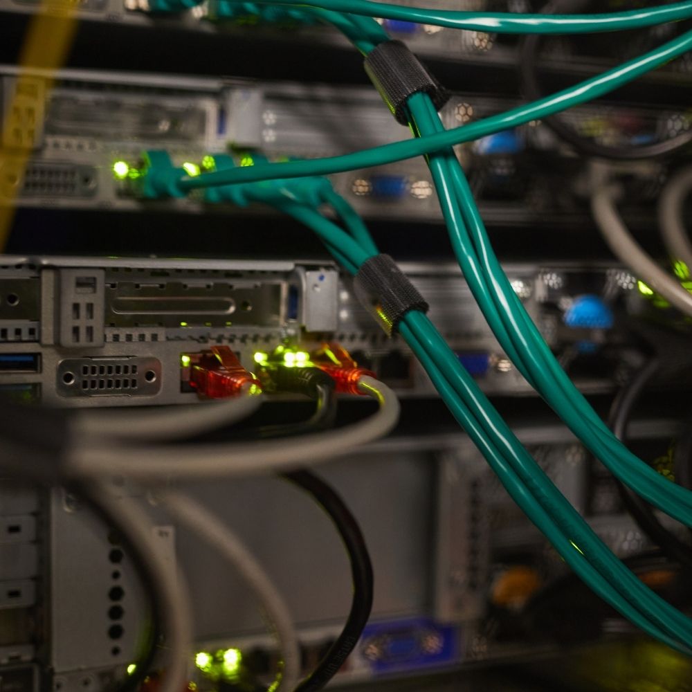 Datakeskuksen palvelimia ja verkkokaapeleita – tekoälyn infrastruktuuri kuluttaa energiaa ja resursseja