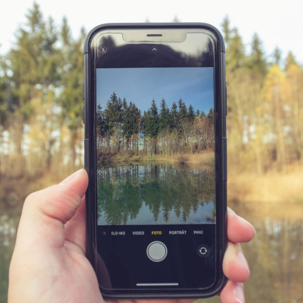 Luontomaisema kuvattuna älypuhelimen näytöllä – teknologian ja luonnon välinen suhde